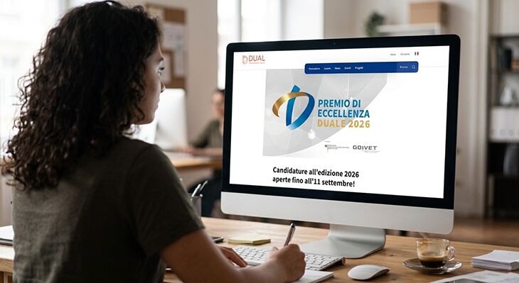 Frau am Schreibtisch betrachtet auf einem Monitor die GOVET-Webseite zum Premio di Eccellenza Duale 2026.