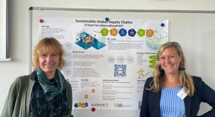 Zwei Frauen von GOVET stehen vor einem bunten VET Plakat und l&auml;cheln in die Kamera.