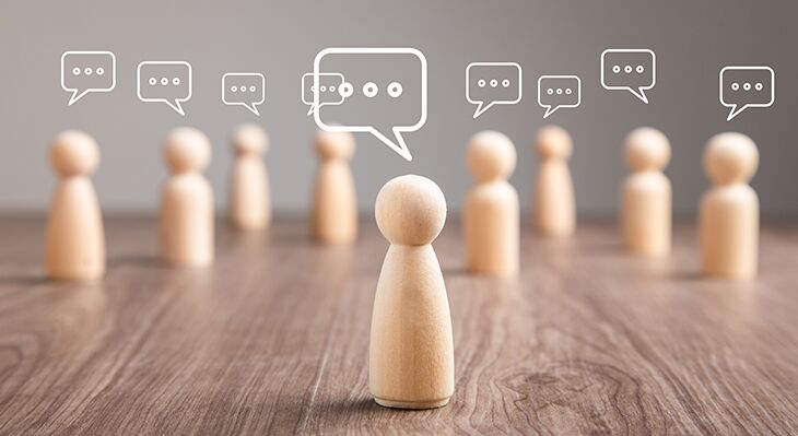 Holzfiguren mit Sprechblasen oberhalb der K&ouml;pfe